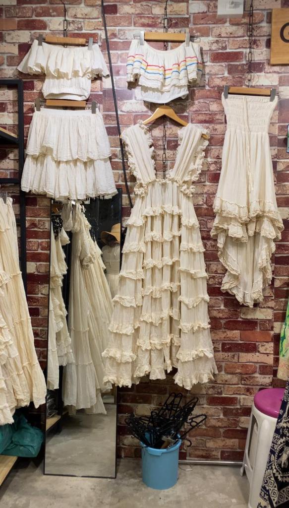 white dresses on display against a brick wall background