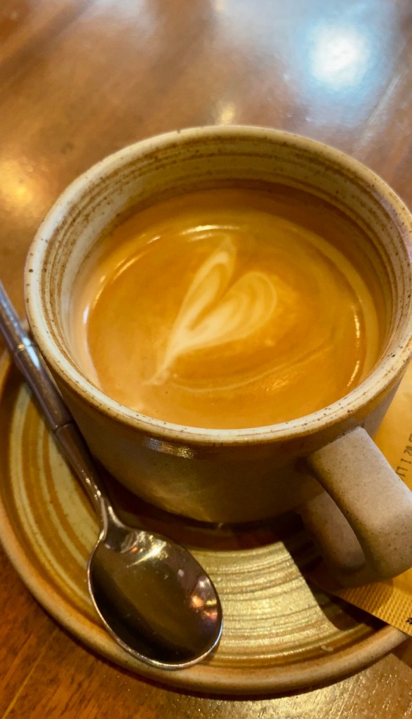 A cup of cortado coffee with heart foam