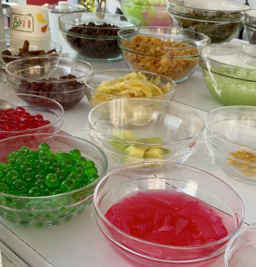 Colorful topping selections in glass bowls for shaved ice dessert